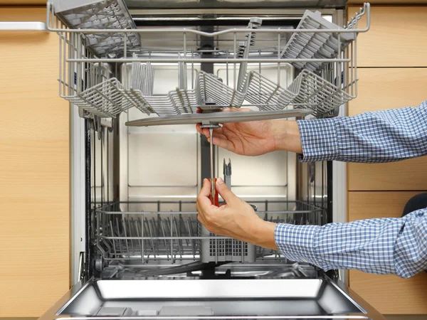 Handyman repairing a dishwasher — Stock Photo, Image