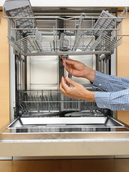 Handyman repairing a dishwasher — Stock Photo, Image