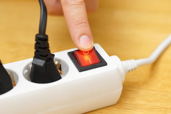 Schalten Sie den Knopf am Stromanschluss aus, um Strom zu sparen. Stockfoto