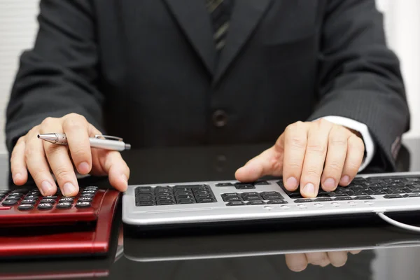 Homem de negócios está trabalhando totalmente em computador e calculadora — Fotografia de Stock