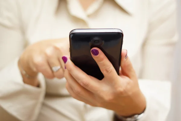 Wanita mengetik di layar sentuh pada ponsel besar — Stok Foto