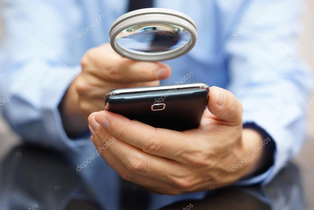 Herunterladen - Geschäftsmann mit Handy mit Lupe. Konzept für Telefonbetrug — Stockbild Geschäftsmann mit Handy mit Lupe. pho — Stockfoto