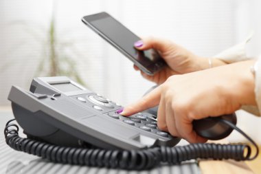 Kadın arazi çizgi telefonla arama ve cep telefonundan arıyorum
