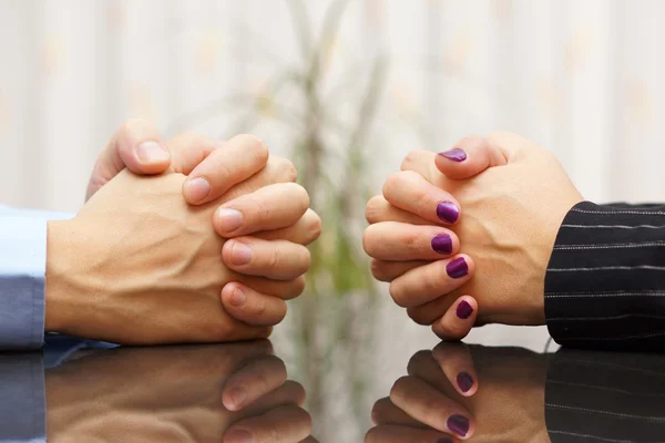 Hombre y mujer se sientan en un escritorio con las manos apretadas. problema matrimonial —  Fotos de Stock