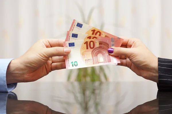 Zakenvrouw geven eurobankbiljetten aan de mens. Salaris concept Rechtenvrije Stockfoto's