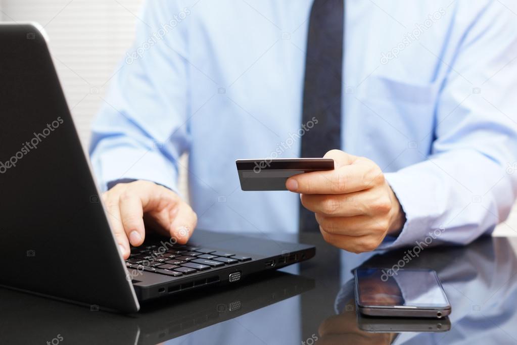 Businessman is using credit card for on line payment on laptop