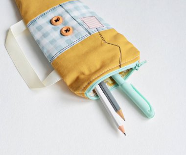 El yapımı fermuar kesesi ve kalemler beyazın üzerine.