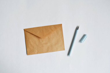 Beyaz arkaplanda Kraft kağıt zarf ve kalem