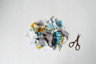 Beyaz arka planda nakış makası ve kumaş artıkları