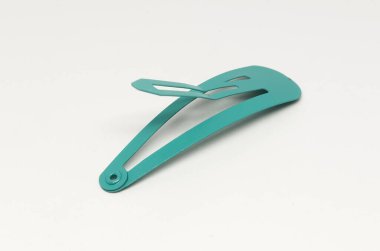 Beyaz arka planda yeşil sörf tokası var. Kuaförün aksesuarı.