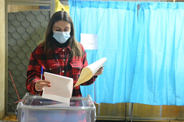 Люди проголосовали на избирательном участке во время всеукраинских местных выборов в Киеве, Украина, 25 октября 2020 года в условиях продолжающейся пандемии коронавируса COVID-19. Украинцы по всей стране отправились на участки для местных выборов.