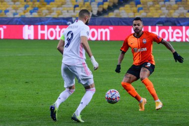 Real Madrid 'den Karim Benzema (L), 1 Aralık 2020 tarihinde Kyiv Olimpiyskiy Stadyumu' nda Shakhtar Donetsk ile Real Madrid arasında oynanan UEFA Şampiyonlar Ligi B Grubu futbol karşılaşması sırasında top ve Shakhtar Donetsk Dentinho (R) ile oynadı..