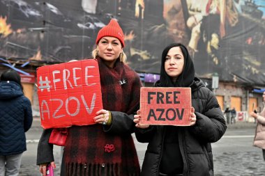 İnsanlar Ukraynalı savaş esirlerini desteklemek amacıyla düzenlenen mitingde üzerinde 