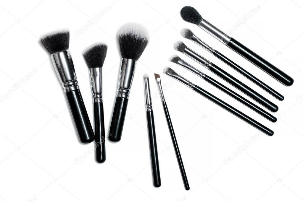 Make-up brushes isolated over white background. Professional makeup brushes. Natural and synthetic bristles, black handles and elegant looking make up artist tools.