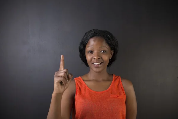 Dél-afrikai vagy afro-amerikai nő tanár kézzel fel a kréta tábla háttér — Stock Fotó