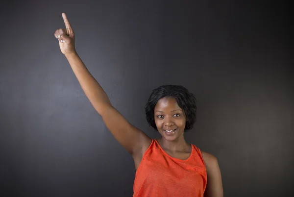 南非或非洲裔美国女人老师手上粉笔黑板背景 — 图库照片