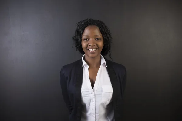 Южноафриканская или афро-американская учительница или ученица на фоне темной доски — стоковое фото