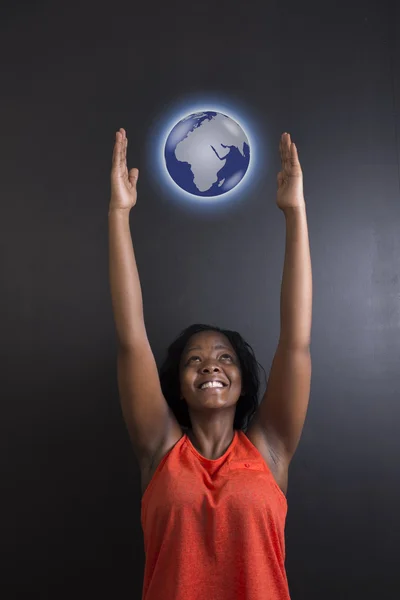 South African or African American woman teacher or student reaching for world earth globe Royalty Free Stock Images