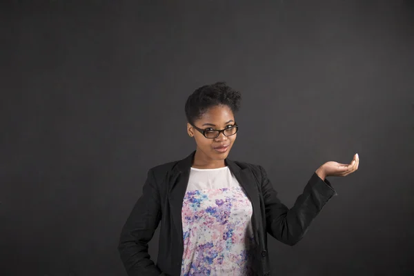 Afrikanerin hält Hand auf Tafel-Hintergrund — Stockfoto