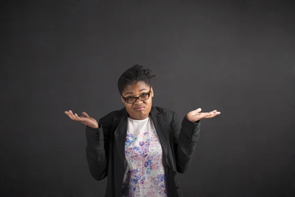 African woman with an I don't know gesture on blackboard background — Stock fotografie