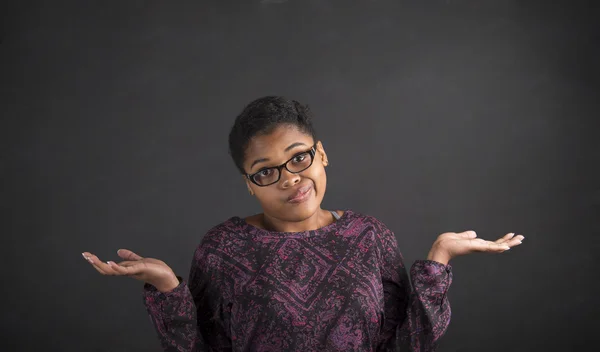 Afrikanerin mit Ich-weiß-nicht-was-Geste auf Tafel-Hintergrund — Stockfoto