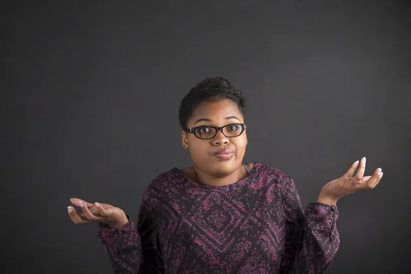 African woman with an I don't know gesture on blackboard background — Φωτογραφία Αρχείου