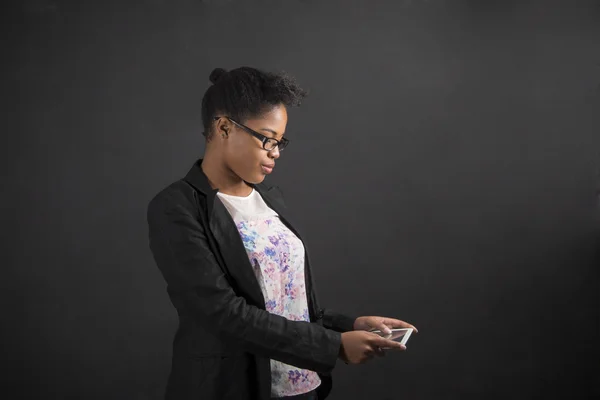 Afrikanerin mit Tablet auf Tafel-Hintergrund — Stockfoto
