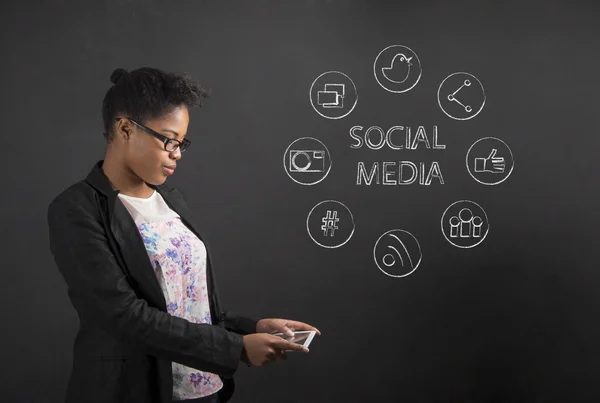 African American woman with tablet social networking on blackboard background — Stock Photo, Image