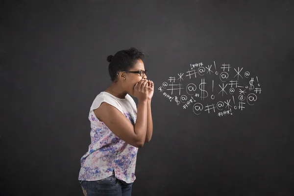 African American woman shouting, screaming or swearing on blackboard background Stockfoto