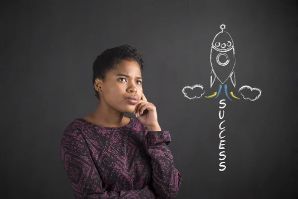 Afro-americano mulher com mão no queixo pensando sobre sucesso rocketing no blackboard fundo — Fotografia de Stock