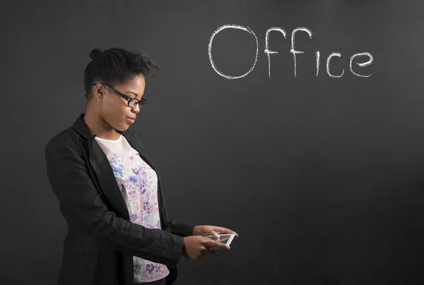 Afrikanerin mit Tablet im Büro auf Tafel-Hintergrund — Stockfoto