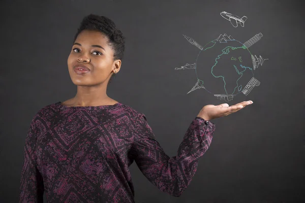 African woman holding hand out with a globe for travel on blackboard background — Stock fotografie