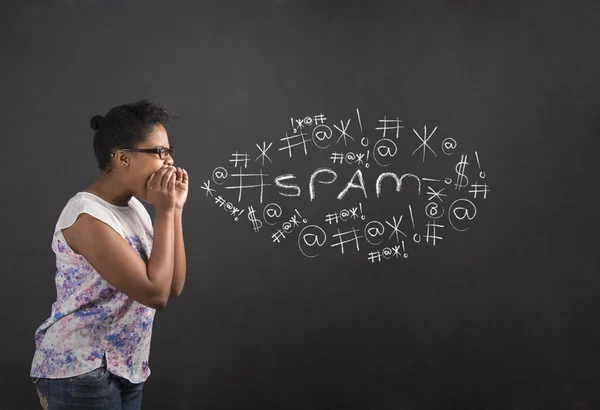 African American woman shouting, screaming or swearing spam on blackboard background — Stock Photo, Image