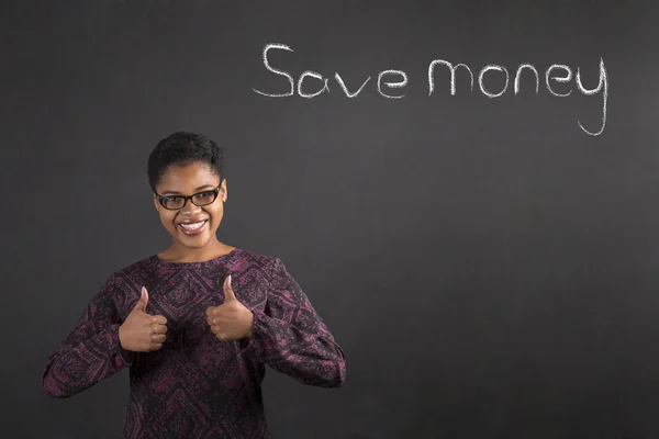 African woman with thumbs up hand signal to saving money on blackboard background Obrazy Stockowe bez tantiem