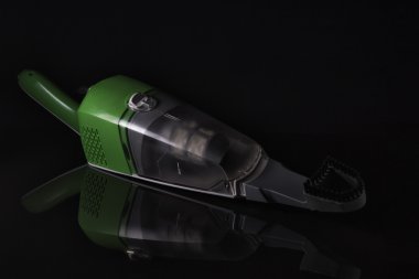 Karanlık bir arka plan üzerinde şarjlı el süpürgesi.