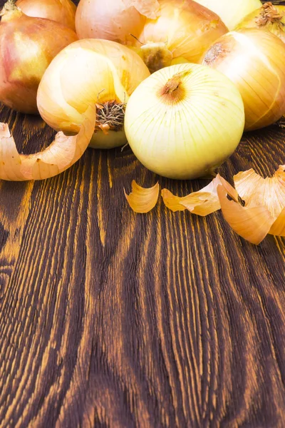 Un montón de cebollas en una mesa de madera — Foto de Stock