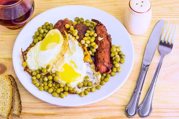 Fried eggs fried eggs with sausage and peas — Stock Photo, Image