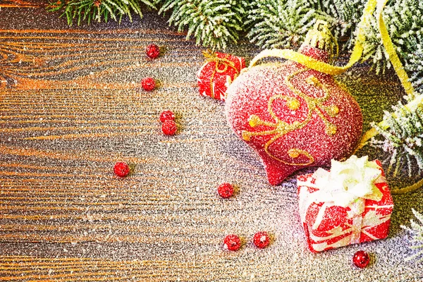 Weihnachtsspielzeug in der Nähe der Nadeln im Schnee — Stockfoto
