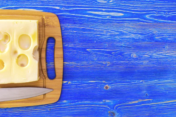 Cheese on a cutting board and knife — Stock Photo, Image