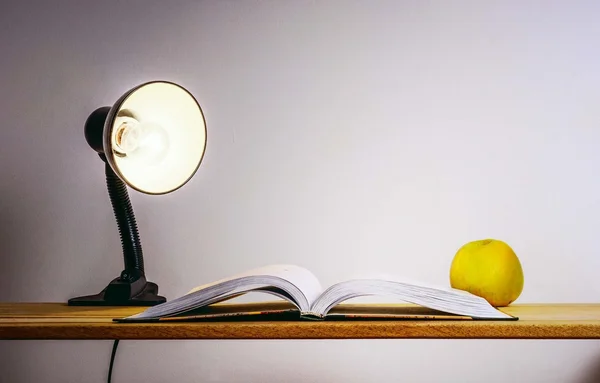 Table lamp, a book and an apple — Stock Photo, Image