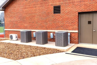 Okul binasının dışındaki HVAC ünitelerinin yatay görüntüsü.