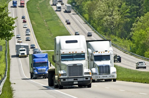 Hellende snelweg met vrachtwagens reizen — Stockfoto