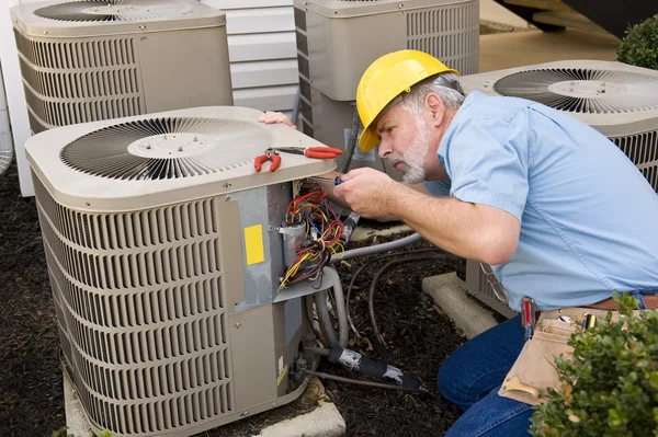 Reparateur werkt op appartement airconditioning Unit Stockfoto