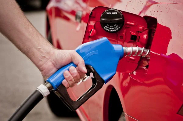 Μπλε αερίου ακροφύσιο αντλιών καυσίμων σε κόκκινο αυτοκίνητο — Φωτογραφία Αρχείου