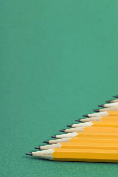 Lápis amarelos afiados em fundo verde — Fotografia de Stock