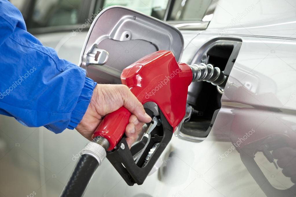 Hand Pumping Gas With Red Fuel Pump