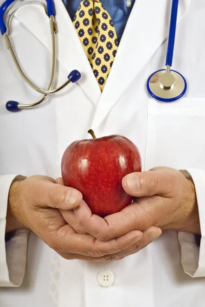 Médico sosteniendo suavemente una manzana roja saludable —  Fotos de Stock