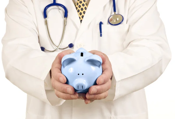 Doctor Holding Out Piggy Bank Solicitando Pagamento — Fotografia de Stock