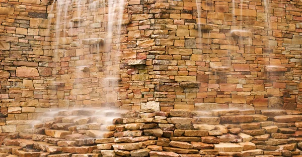 Agua en cascada sobre muro de piedra — Foto de Stock