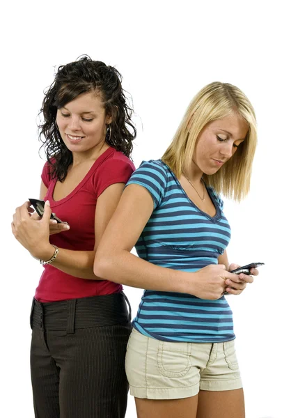 Mensajería de texto de chicas jóvenes en teléfonos celulares — Foto de Stock
